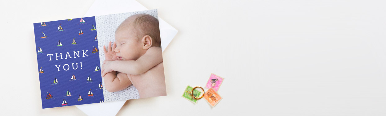 A baby thank you card design. The thank you card is printed with a photo of a baby boy. It has a blue nautical design next to the photo.