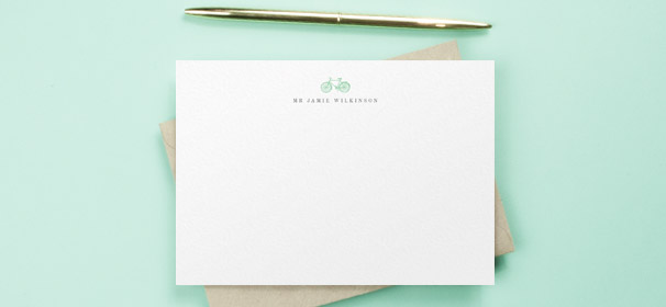 A personalised correspondence card for a man. It is a white note card with a blue bike design above and man’s printed name. 