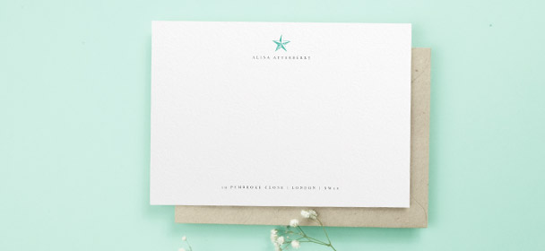 A personalised correspondence card for women. It is a traditional white note card printed with a name, address and simple green star motif.