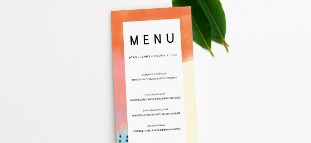 A printed modern wedding menu design. The menu has an abstract orange and yellow border, with the wedding menu text written in black.