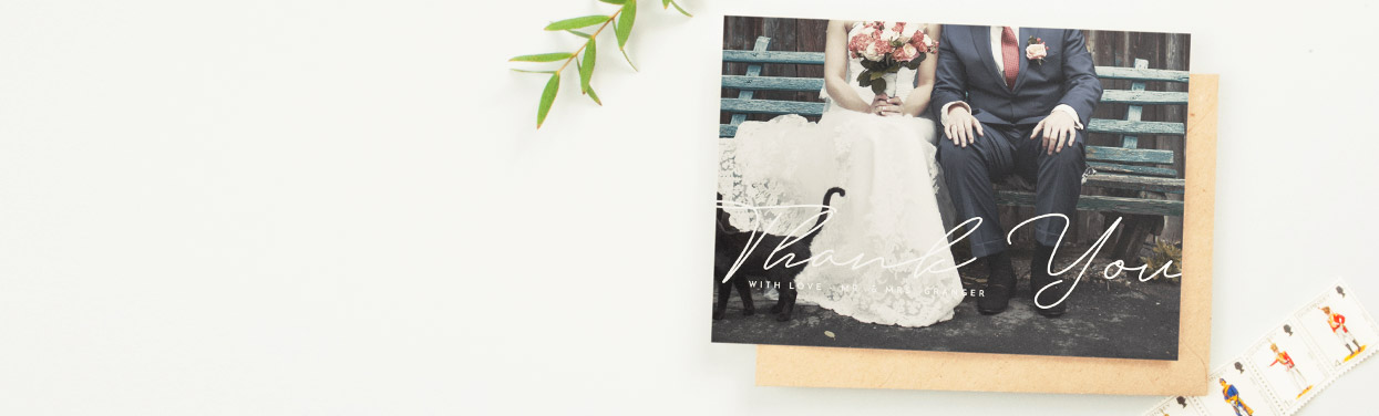 A simple wedding thank you card design with a full-page photo of the bride and groom. ‘Thank you’ has been printed in white over the couple’s photo.