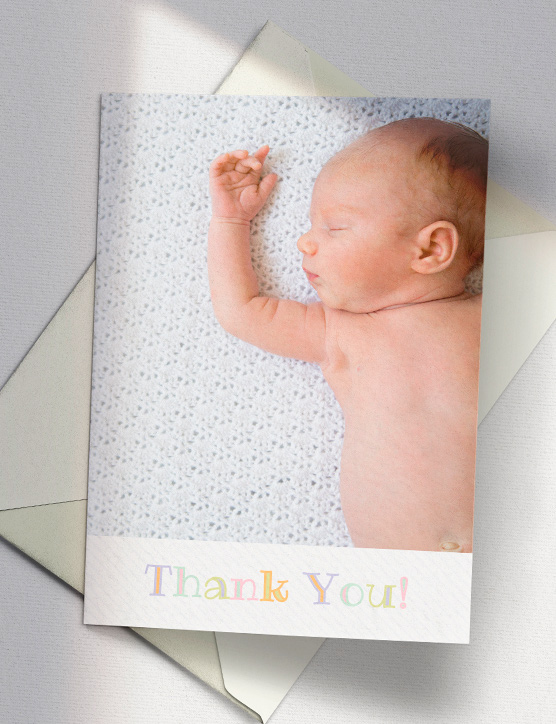 A christening thank you card with a photo from the baptism ceremony. The thank you card has “Thank you” printed underneath the photo.