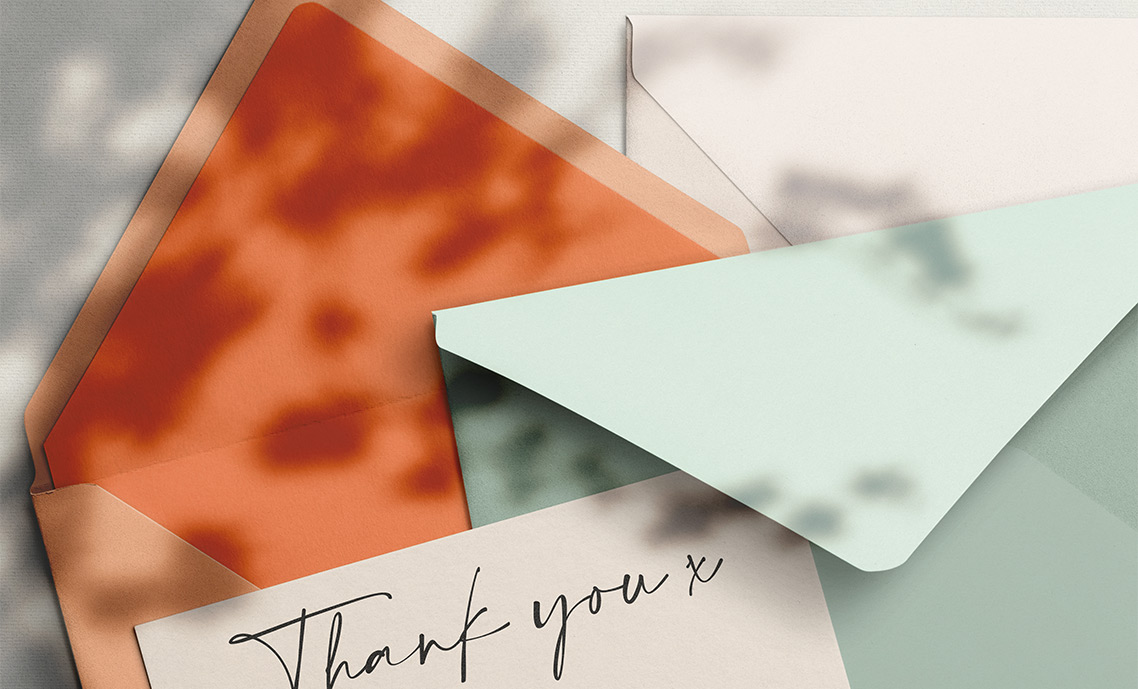 A printed wedding thank you card showing a married couple eating their wedding cake. The card reads “Thank You”