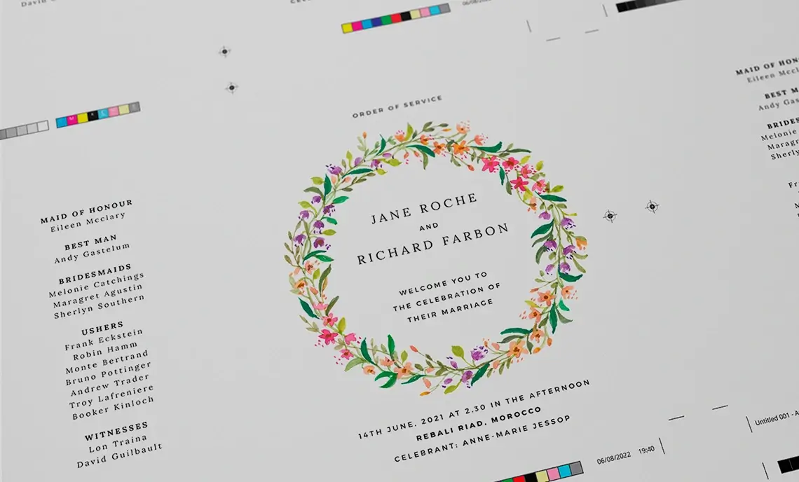 Printer's layup of a wedding order of service booklet cover, with printers marks and color reference bars, featuring an intricate floral wreath design.