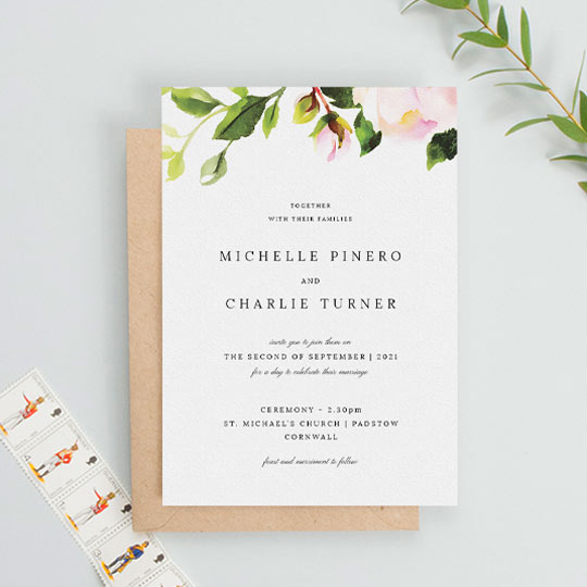 A classic floral wedding invitation which is predominantly white, apart from a painted rode and leaf element at the top of the card. The rest of the card is printed with a black, classic font arrangement.