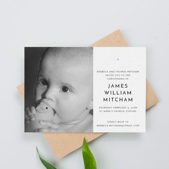 A simple christening invitation with a baby photo on the right-hand side. There is a black and white photo on the left of the christening invitation. The right-hand side has a small, gold crucifix.