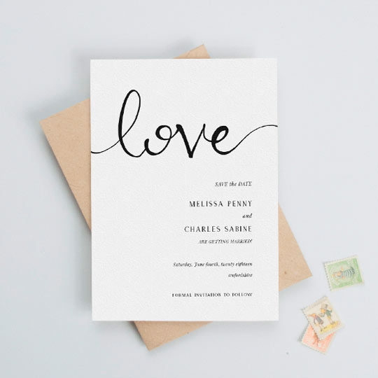 A classic, simple wedding save the date card. It is a black and white save the date card with the word “love” handwritten at the top. The wedding information is printed on the bottom written of the save the date.