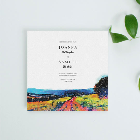 A country, rustic wedding save the date card. It is predominantly white with a watercolour-painted countryside vista at the bottom. The details of an upcoming wedding are printed at the top in a black font.