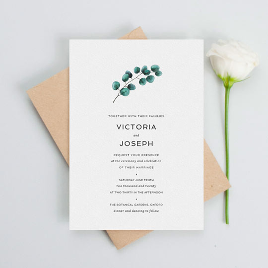 And elegant wedding invitation design with a floral touch. The main design feature of this wedding invitation is a painted eucalyptus leaf branch. It is dark green and sits above some elegant wedding invitation text beneath in black.