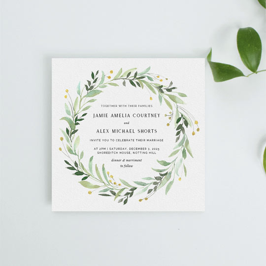 A spring floral wedding invitation. This wedding invitation design had light green and mint leaves with small yellow flower buds. It has black wedding invitation text in the middle of the floral wreath.