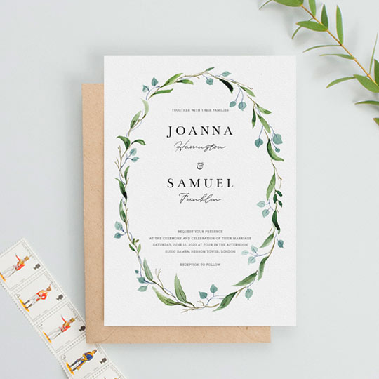 An elegant and floral wedding invitation with a beautiful green and blue watercolour wreath. The centre of the wedding invite has text made up of several contrasting fonts.