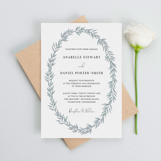 A modern floral wedding invitation design with a light blue abstract wreath on a white background. The wedding invitation’s text is printed in black.