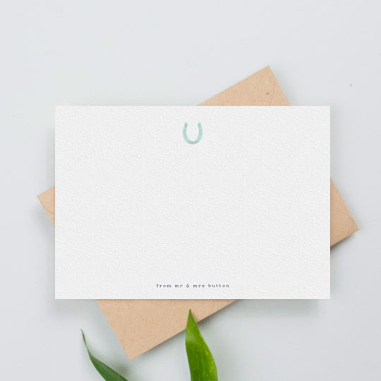 A personalised note card with a blue horseshoe printed at the top. The name of a couple if printed at the bottom.