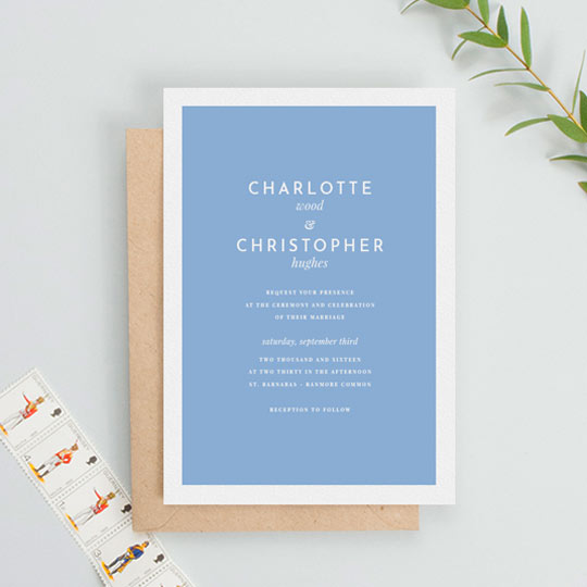 A classic and simple wedding invitation card design. The body of the wedding invitation is made of a light blue background, surrounded by a thick white border. The wedding invitation text is simplistic and classic at the same time