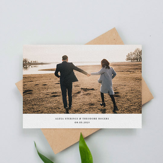 A landscape wedding invitation photo card. This is a classic design with a large colour photo on top of a white area with the names of a married couple and the date of their wedding.