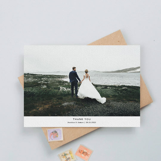 A landscape photo wedding thank you card design with a large colour photo of a married couple. Underneath is a think white section with a personalised message of thanks from the bride and groom