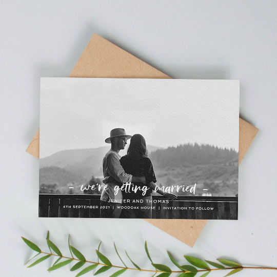 A modern, photo wedding save the date card with “we’re getting married” written across the bottom of the card. The save the date has a full-page, black and white photo.