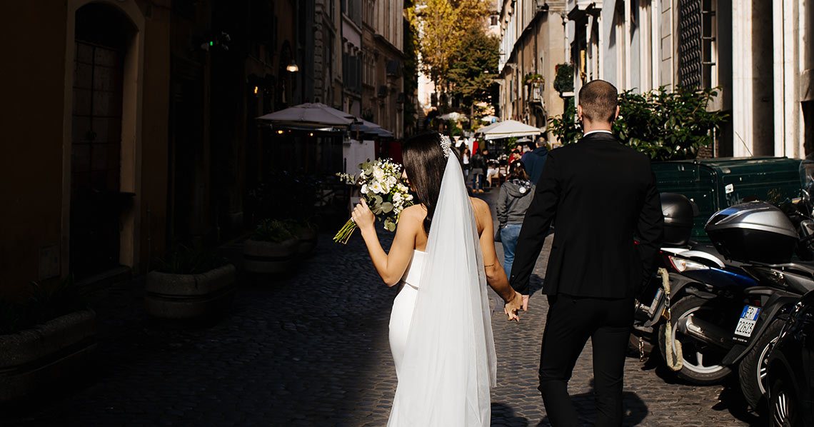 A bride and groom walking away from their classic wedding ceremony.