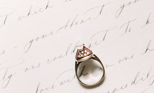 An engagement ring sat on a handwritten thank you card.