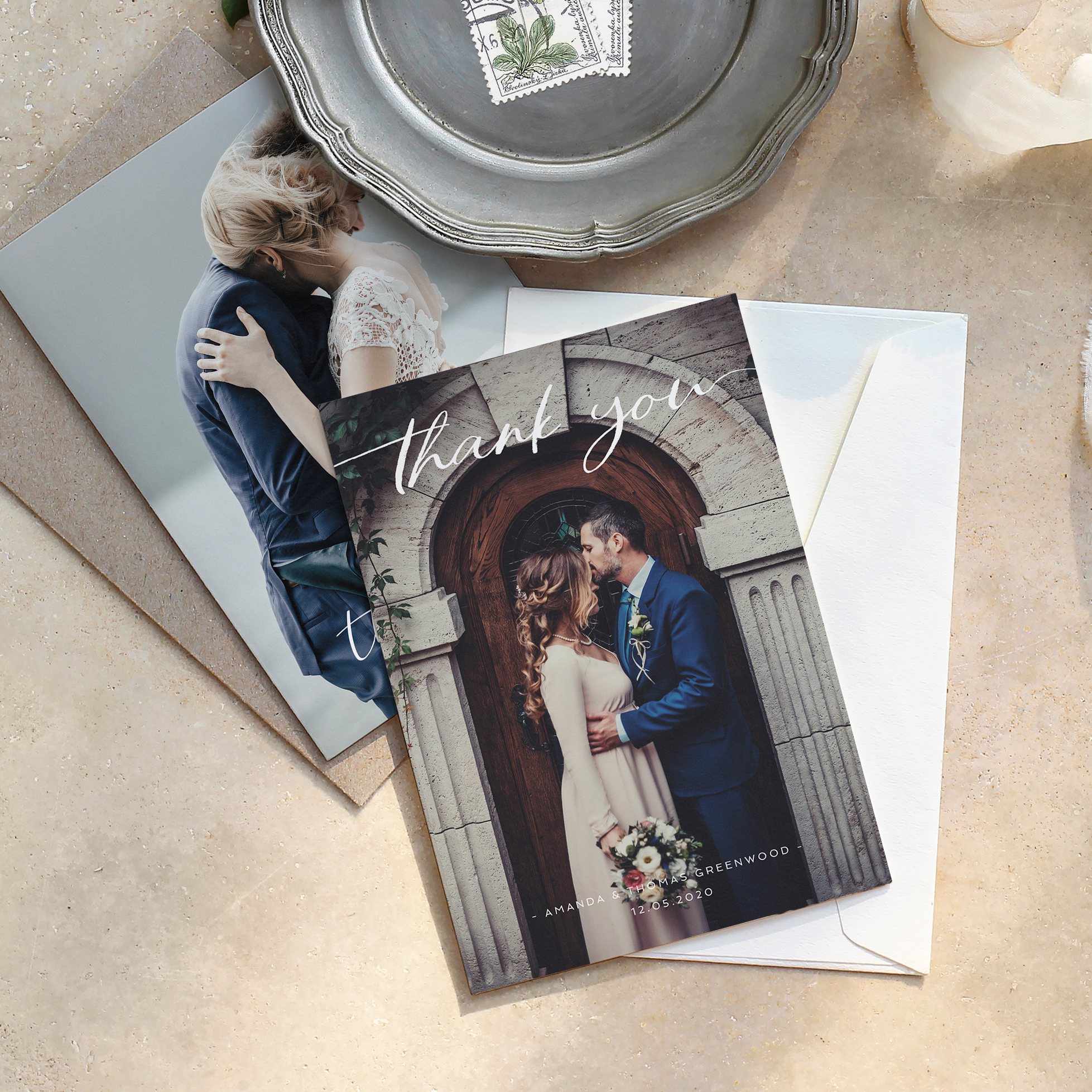 A full-page wedding thank you card lying on a marble table.