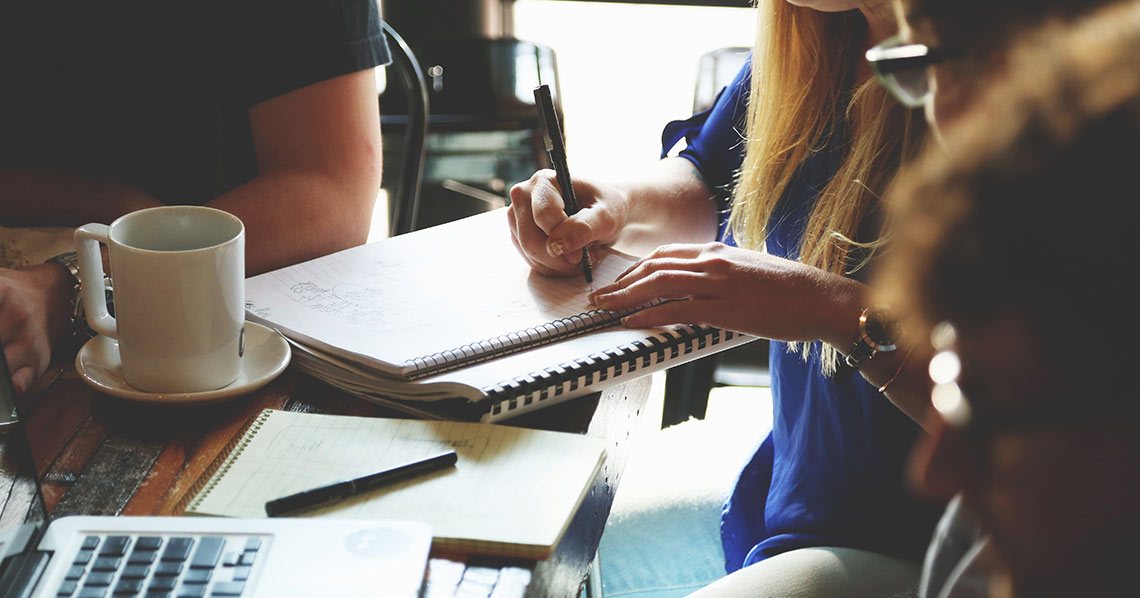 A lady writing a thank you note in a cafГ©.