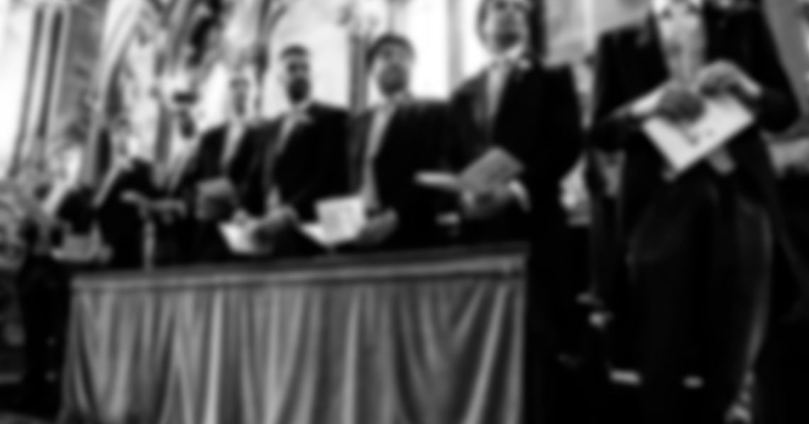 Ushers standing in a church for a wedding ceremony.