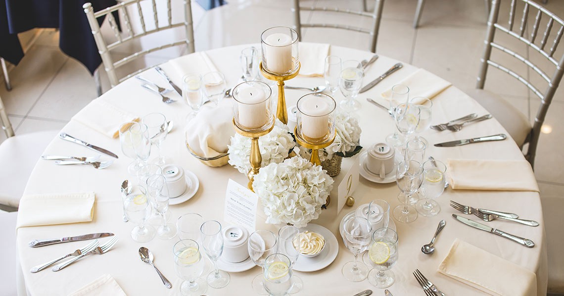 Elegant wedding reception table setup with beautiful centerpiece and fine diningware.