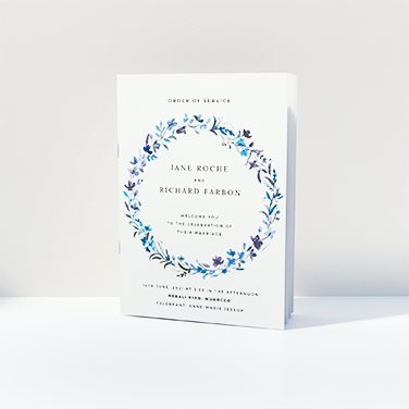 A wedding order of service printed with a blue floral wreath.