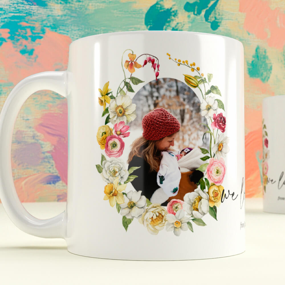 Children’s personalised mug featuring a floral wreath and a photo of a mother and baby in winter, printed on a white ceramic mug