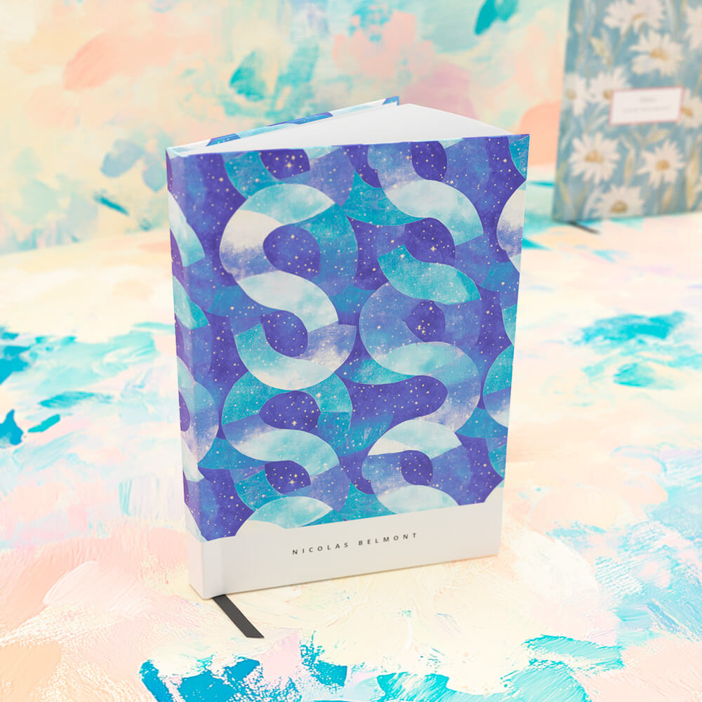 Personalised notebook with an abstract blue and purple design, displayed on a pastel background with a second notebook blurred in the distance