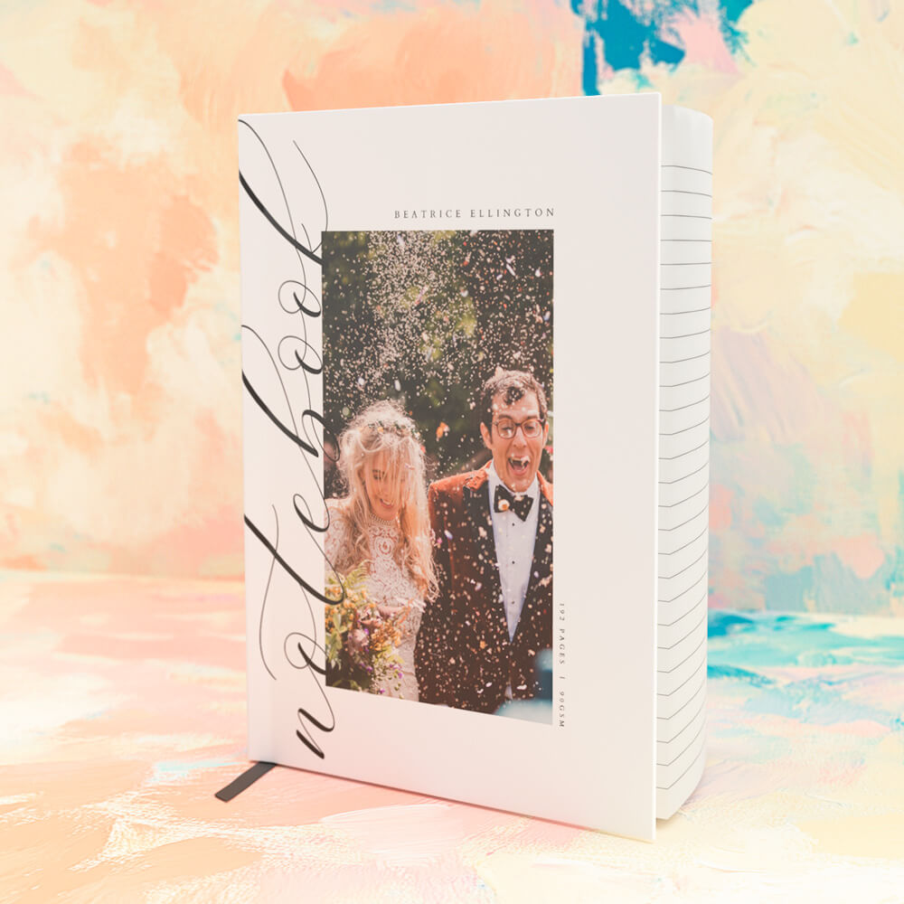 Personalised wedding notebook with a photo cover showing a newlywed couple celebrating with confetti, set against a colourful background
