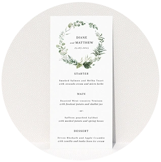 Greenery-themed wedding menu card with botanical wreath